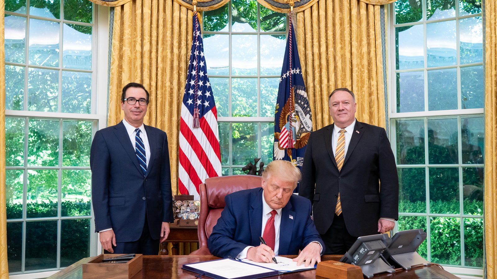 President Trump signs an executive order in the Oval Office
