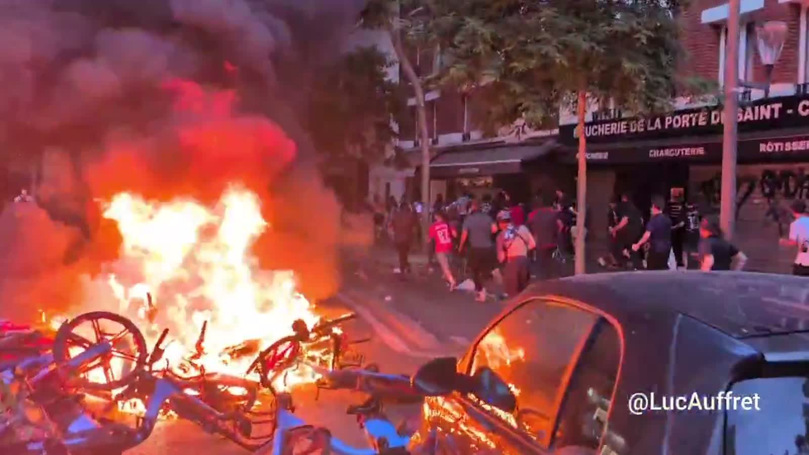 Burning bikes and smoke fill a Paris street after PSG fans celebrated the Champions League victory