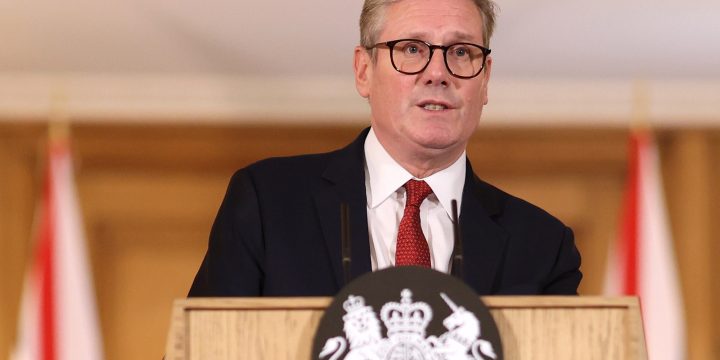 UK Prime Minister Keir Starmer speaks at a press conference behind a podium.