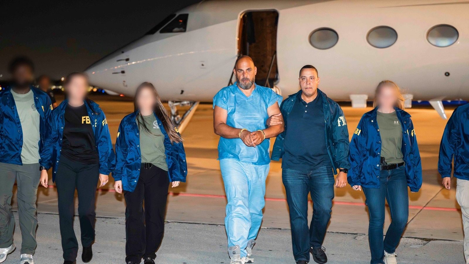 Official photo from the FBI showing Ibrahim Khaldoon Hilmi in custody on a tarmac beside an aircraft