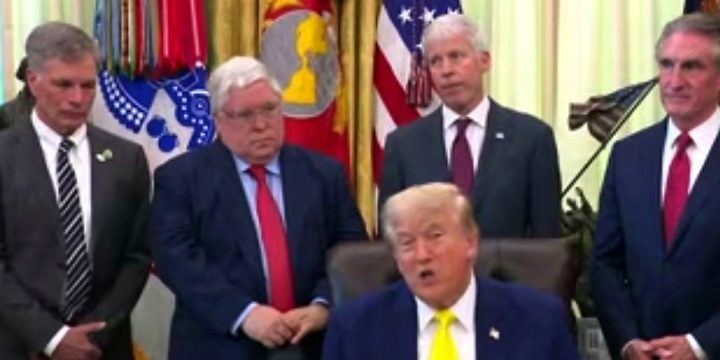President Trump speaking in the Oval Office with officials behind him