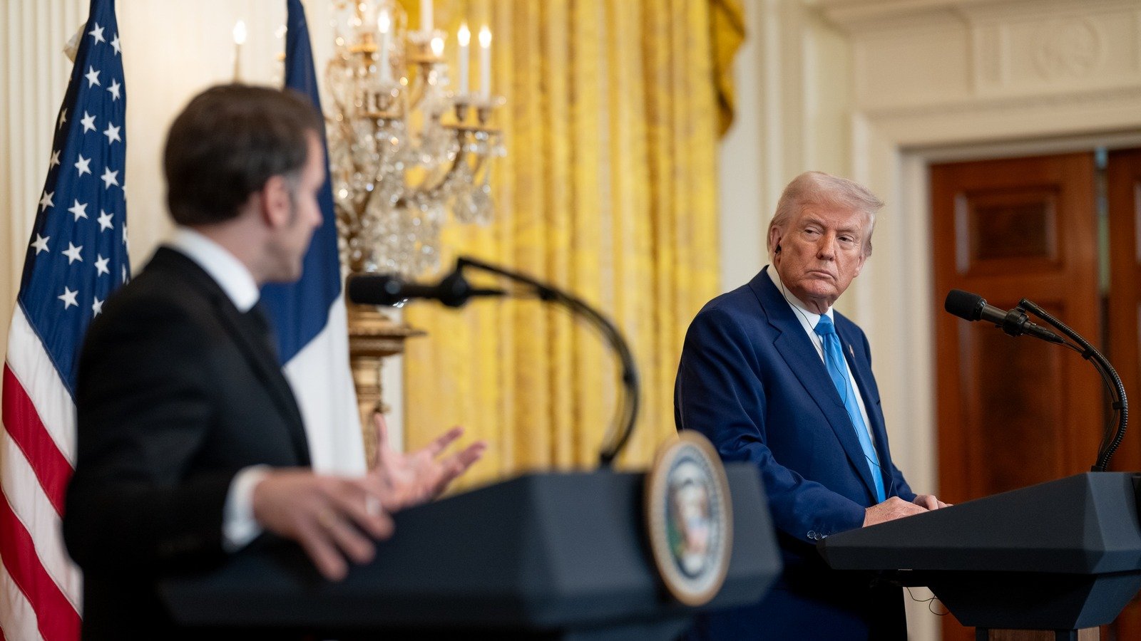 President Trump looks toward French President Emmanuel Macron during a White House press conference