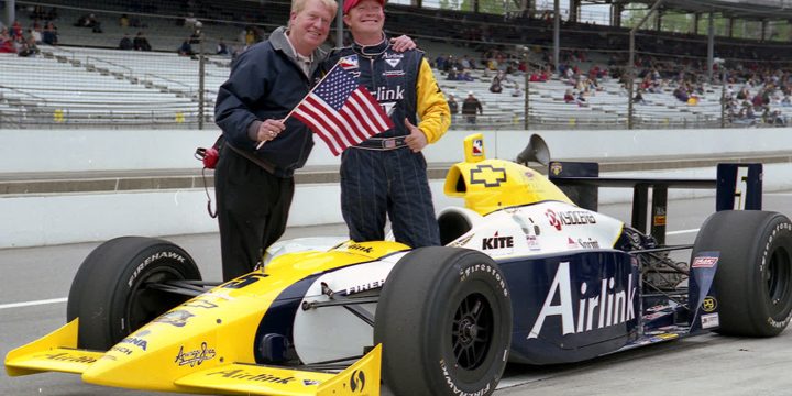 Rick Treadway stands beside an IndyCar at Indianapolis Motor Speedway