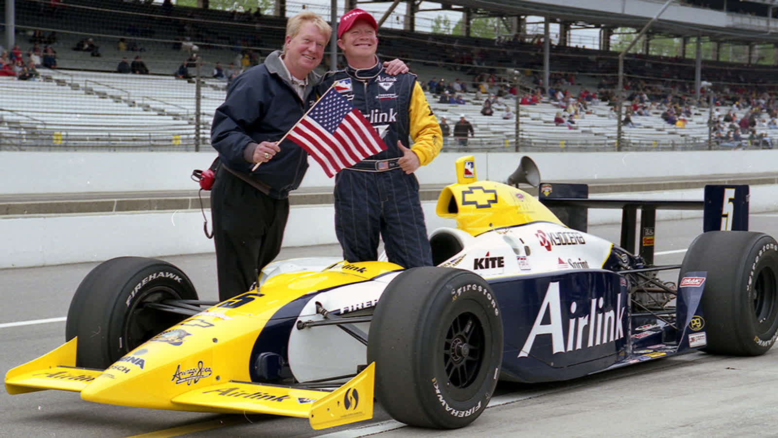 Rick Treadway stands beside an IndyCar at Indianapolis Motor Speedway