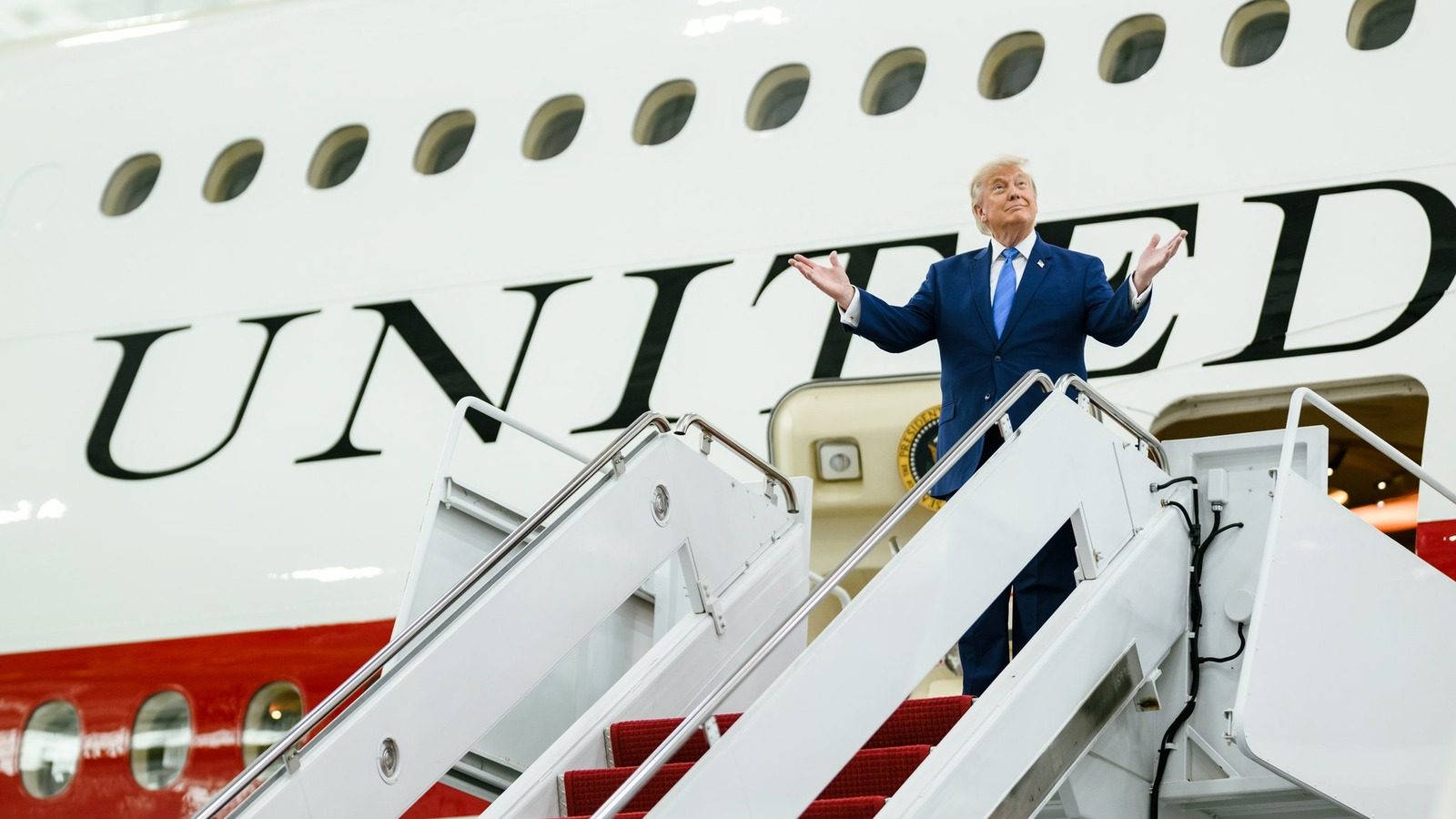 President Trump stands on the stairs of the new Air Force One