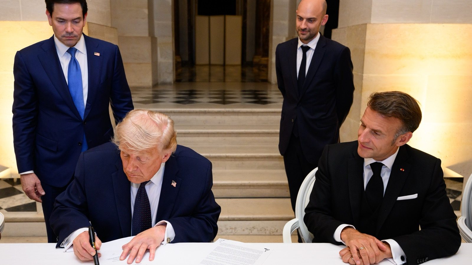 President Trump signs a document during June 2026 foreign policy meetings