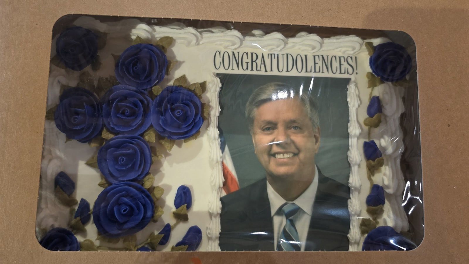 Cake bearing Lindsey Graham's photograph and the word Congratudolences