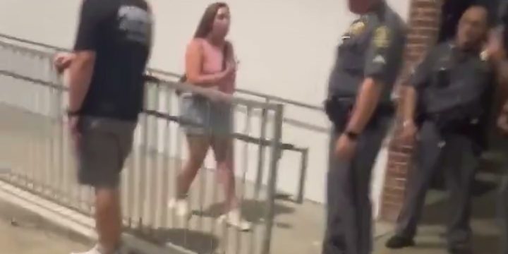 Family members speaking with uniformed officers inside M&T Bank Stadium after a Morgan Wallen concert incident