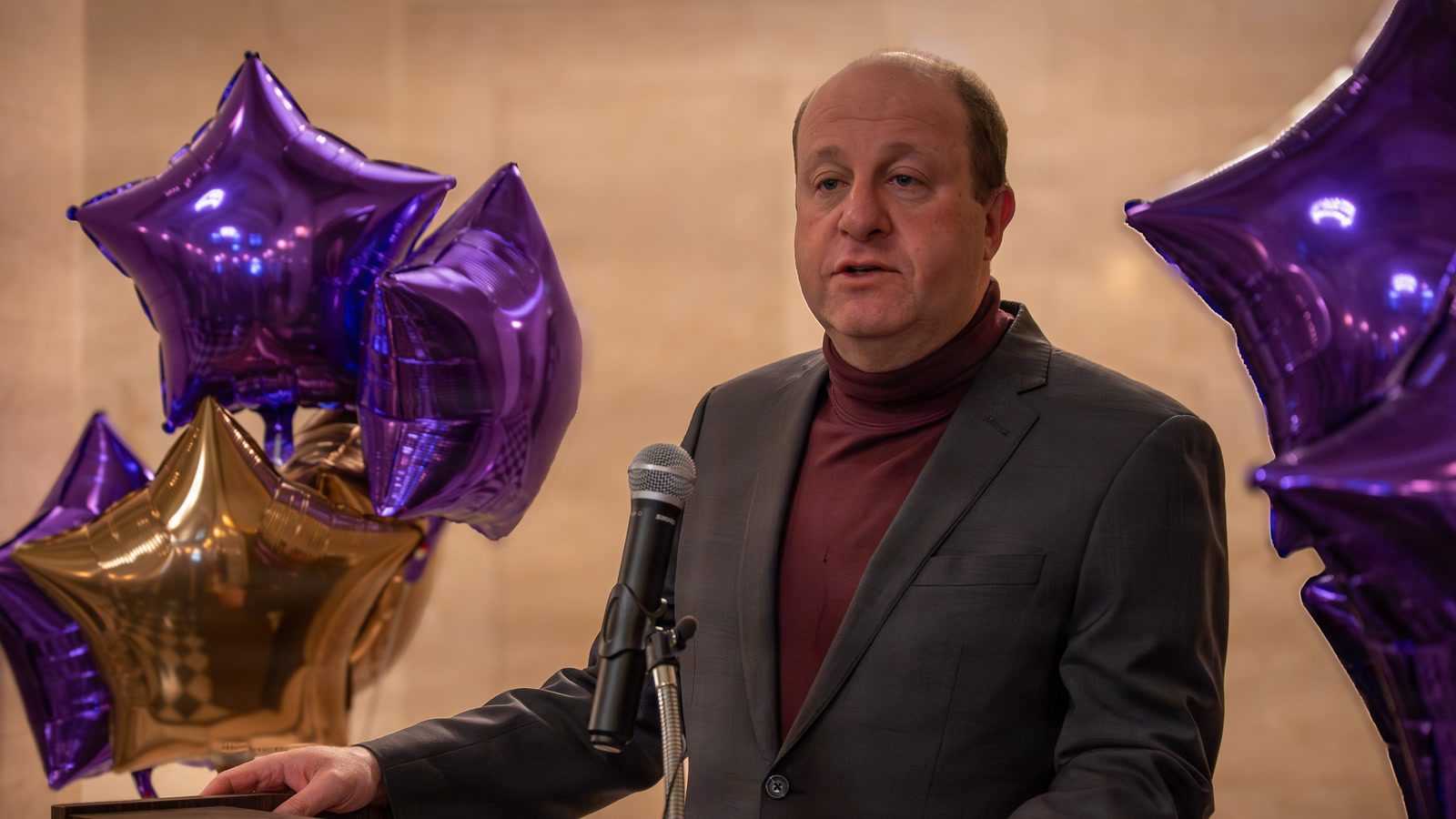 Colorado Gov. Jared Polis speaks at a podium in Denver in April 2026