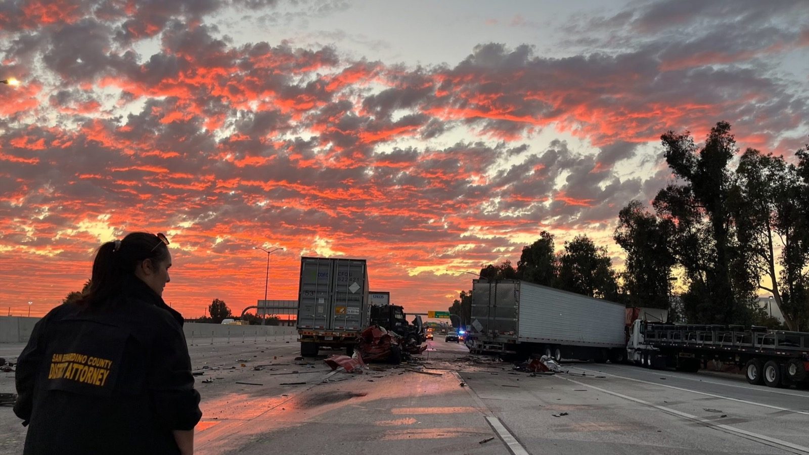 San Bernardino County investigator surveys wrecked trucks after the fatal Interstate 10 crash in Ontario, California