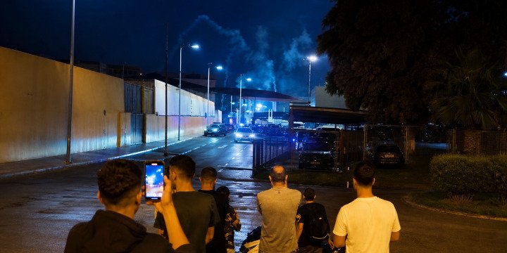 Smoke rises over the Beni Enzar border area in Melilla, Spain, as residents watch the checkpoint on July 30, 2026