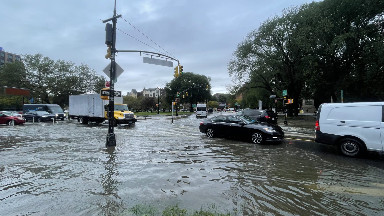 File photo shows cars and trucks moving through floodwater at a New York City intersection near Prospect Park