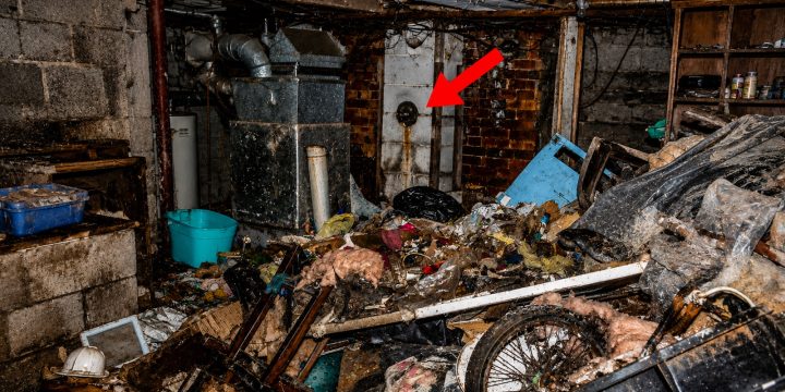 Trash-filled basement inside the Hamden, Ohio, home with a red arrow marking an opening in the wall