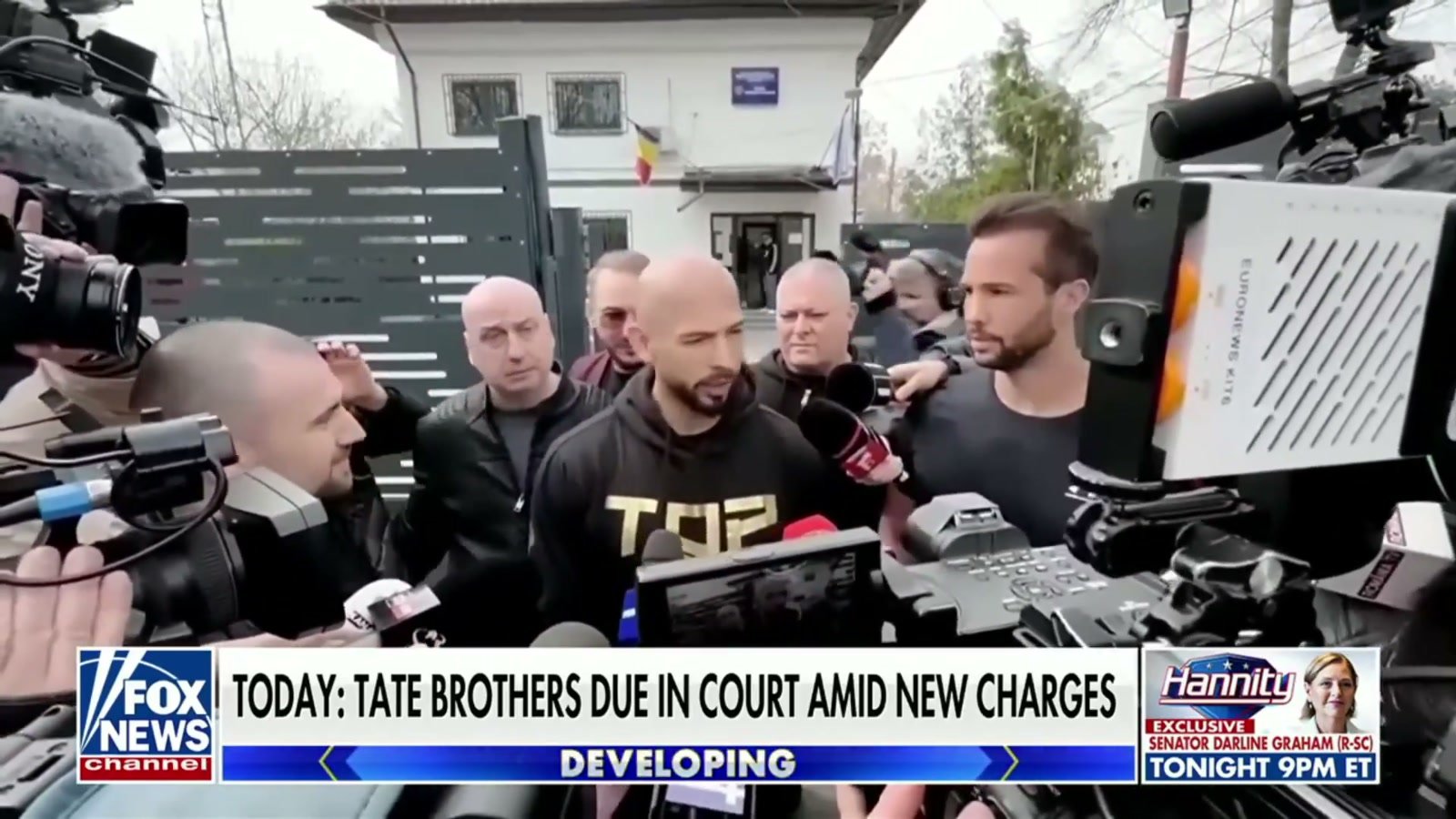 Andrew and Tristan Tate surrounded by members of the press