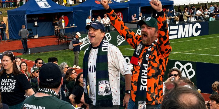 Troy Jackson and Graham Platner cheer at a Portland Hearts of Pine soccer match.
