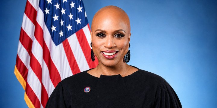 Official portrait of Rep. Ayanna Pressley in front of an American flag