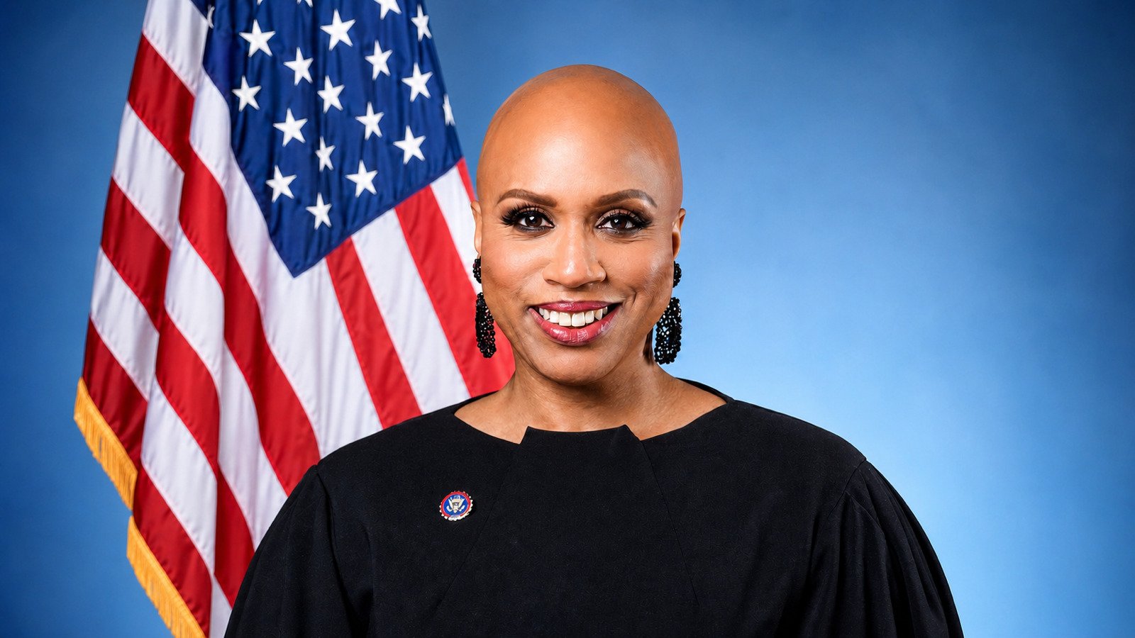Official portrait of Rep. Ayanna Pressley in front of an American flag