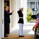 President Trump waves beside a saluting United States Marine at the White House in May 2017